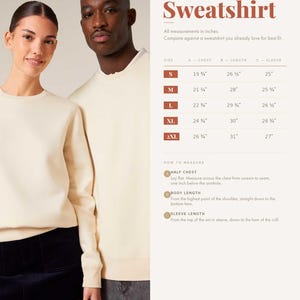 May include: A cream-colored crewneck sweatshirt shown on two individuals, accompanied by a size chart titled Organic Sweatshirt. The chart lists measurements in inches for sizes S through 2XL, including chest, length, and sleeve length details.