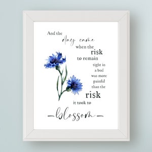May include: A watercolour illustration of blue cornflowers with a quote that reads: "And the day came when the risk to remain tight in a bud was more painful than the risk it took to blossom."
