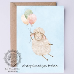 以下が含まれることがあります： 3つの風船を持った羊の水彩イラストが描かれたバースデーカード。羊は白で、茶色の足と笑顔の顔をしています。風船はパステルカラーです。「Wishing Ewe a Happy Birthday」と書かれています。