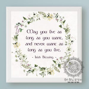 May include: A white framed print with a watercolor floral wreath surrounding an Irish blessing that reads "May you live as long as you want, and never want as long as you live." The quote is in a dark purple font.