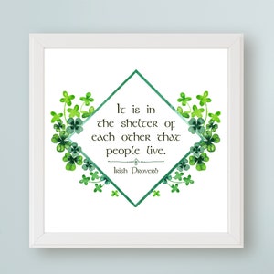 May include: A white framed print with a green shamrock border. The print features a green diamond with a white outline and the text "It is in the shelter of each other that people live. Irish Proverb".
