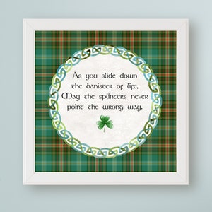 May include: A green and red plaid background with a white circle containing a Celtic knot design and the text "As you slide down the banister of life, May the splinters never point the wrong way." A green four-leaf clover is in the center of the circle.