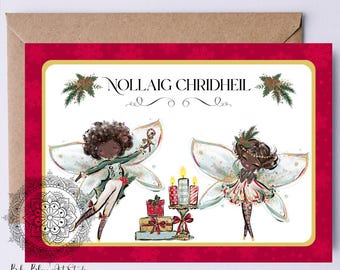 Può includere: Un biglietto di Natale con bordo rosso e interno bianco. Il biglietto presenta due illustrazioni di fate con le ali, che tengono candele e regali. Il testo "NOLLAIG CHRIDHEIL" è in alto. Il biglietto è all'interno di una busta marrone.