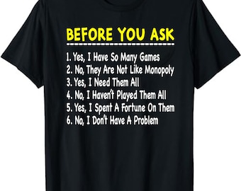 May include: Black t-shirt with the text "BEFORE YOU ASK" in yellow and white. Below the title are six numbered statements about games, including "Yes, I Have So Many Games" and "No, I Don't Have A Problem."