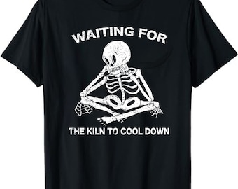 May include: Black t-shirt with a white skeleton sitting with its legs crossed and the text "Waiting for the kiln to cool down".