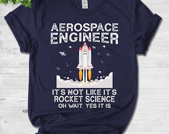Op de afbeelding: Marineblauw T-shirt met de tekst "AEROSPACE ENGINEER" en een afbeelding van een raket. Daaronder staat de tekst "IT'S NOT LIKE IT'S ROCKET SCIENCE OH WAIT, YES IT IS".