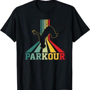 May include: Black t-shirt featuring a retro design with a silhouette of a person doing a parkour flip. The design includes colorful stripes and the word "PARKOUR" in a vintage font.