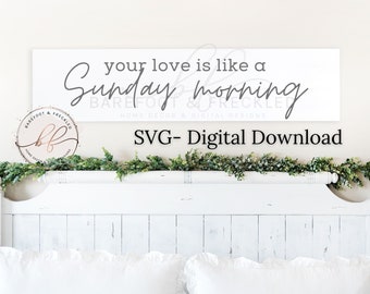 May include: White sign with gray text that reads "your love is like a Sunday morning" with the words "Barefoot & Freckled" and "Home Decor & Digital Designs" below. The sign is on a white headboard with a green garland on top.