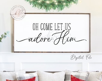 May include: A white sign with black text that reads "Oh Come Let Us Adore Him". The sign is framed in wood and is sitting on a white mantel. There are three pillows on a couch below the mantel, two are red with a gold Christmas tree design and one is gray and white.