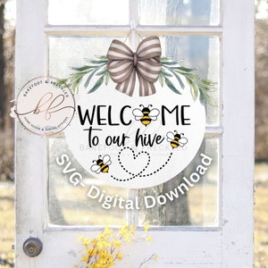 May include: A white round sign with the text "Welcome to our hive" and three cartoon bees. The sign has a brown and white striped bow and green leaves around the edge. The text "SVG-Digital Download" is written below the sign.