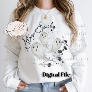 May include: White sweatshirt with a black and gray ghost design and the text "Stay Spooky".