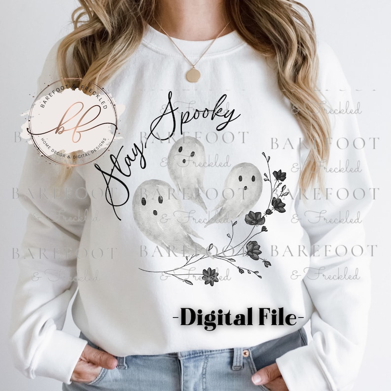 May include: White sweatshirt with a black and gray ghost design and the text "Stay Spooky".