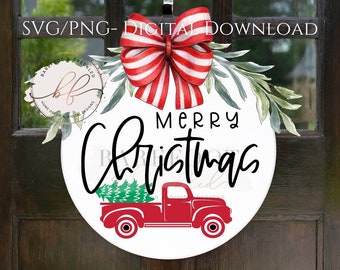 Könnte beinhalten: Ein weißes rundes Schild mit dem Text "Merry Christmas" in schwarzer Schrift. Unter dem Text befindet sich ein roter Pickup mit einem grünen Weihnachtsbaum in der Ladefläche. Oben auf dem Schild befindet sich eine rot-weiß gestreifte Schleife mit grünen Blättern.