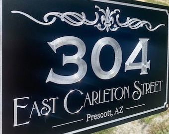 May include: Black rectangular address sign with silver lettering and decorative flourishes. The sign shows the number "304" above "East Carleton Street, Prescott, AZ".