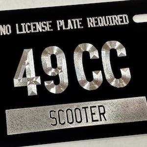 May include: Black license plate with silver lettering that reads "NO LICENSE PLATE REQUIRED" and "49CC SCOOTER".