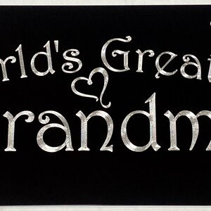 May include: Black license plate with silver lettering that reads "World's Greatest Grandma" with a heart symbol between the words.