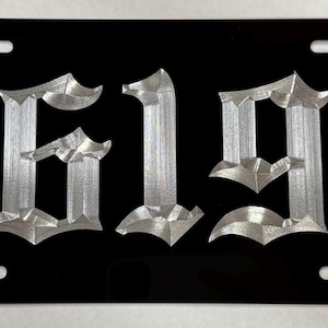 May include: Black license plate with silver 3D lettering that reads "619".