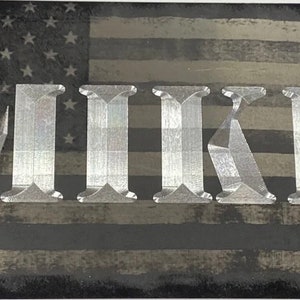 May include: A black and white American flag license plate with the name "MIKE" in silver lettering.