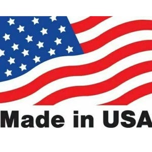 K&ouml;nnte beinhalten: Eine Grafik mit einer stilisierten, wellenf&ouml;rmigen amerikanischen Flagge mit einem blauen Feld mit wei&szlig;en Sternen und abwechselnden roten und wei&szlig;en horizontalen Streifen. Unter der Flagge steht der Text "Made in USA" in fetten, schwarzen Gro&szlig;buchstaben.