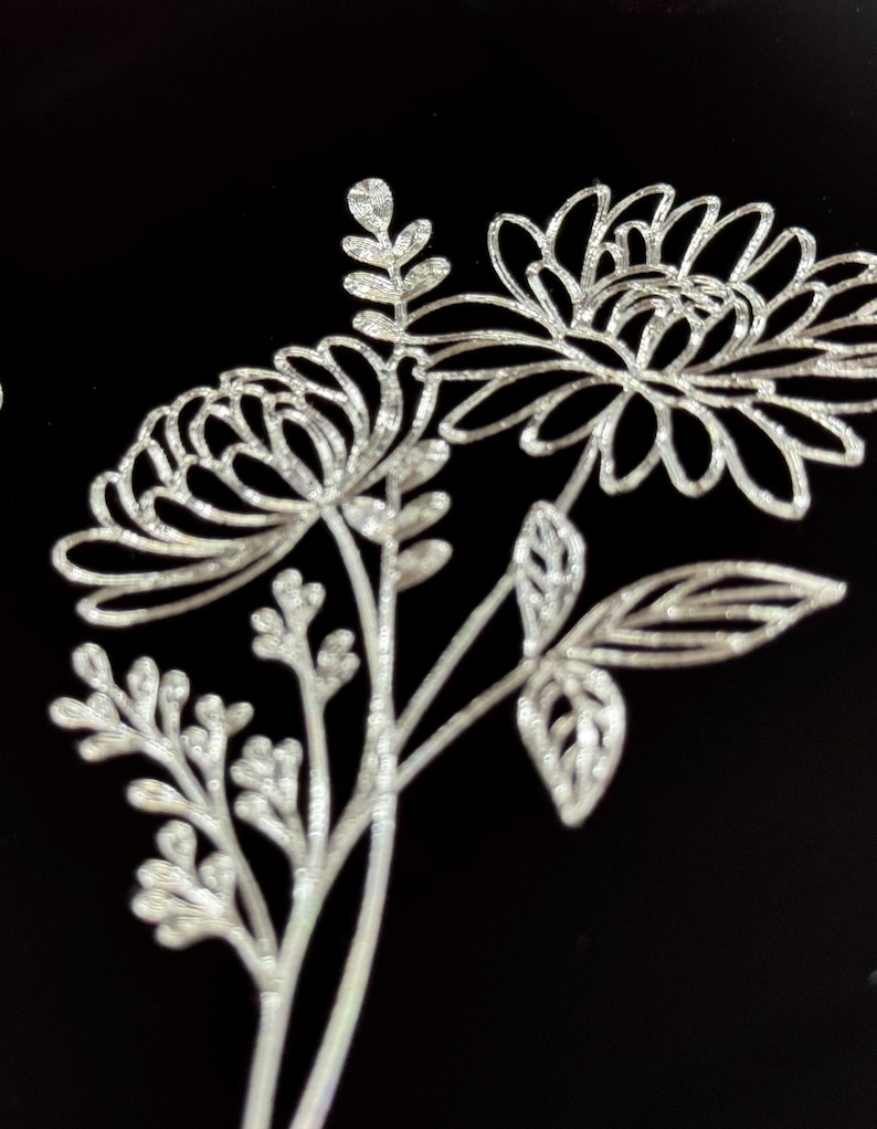 Peut inclure: Un motif floral argent&eacute; paillet&eacute; avec trois fleurs et des feuilles sur un fond noir.