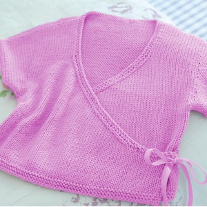 May include: A pink knitted wrap top with short sleeves and a tie at the waist.