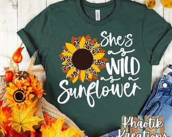 May include: A green t-shirt with a white graphic of a sunflower with a leopard print design. The text on the shirt reads "She's as wild as a sunflower".