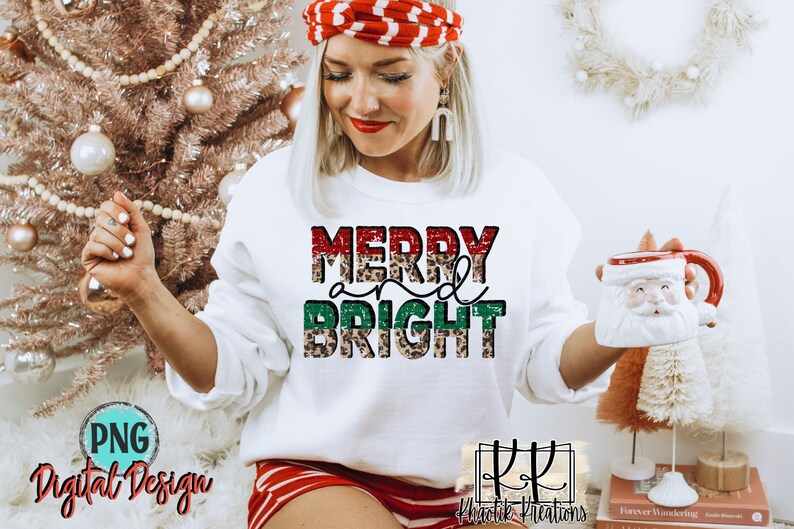 May include: White sweatshirt with the text "Merry and Bright" in red, green, and leopard print. The text is layered with glitter.