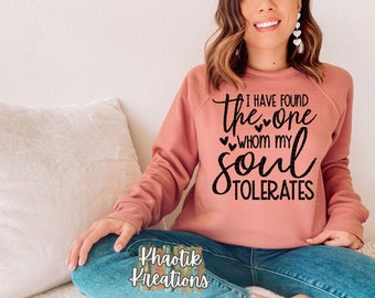 May include: A pink sweatshirt with the text "I have found the one whom my soul tolerates" in black lettering with small hearts.