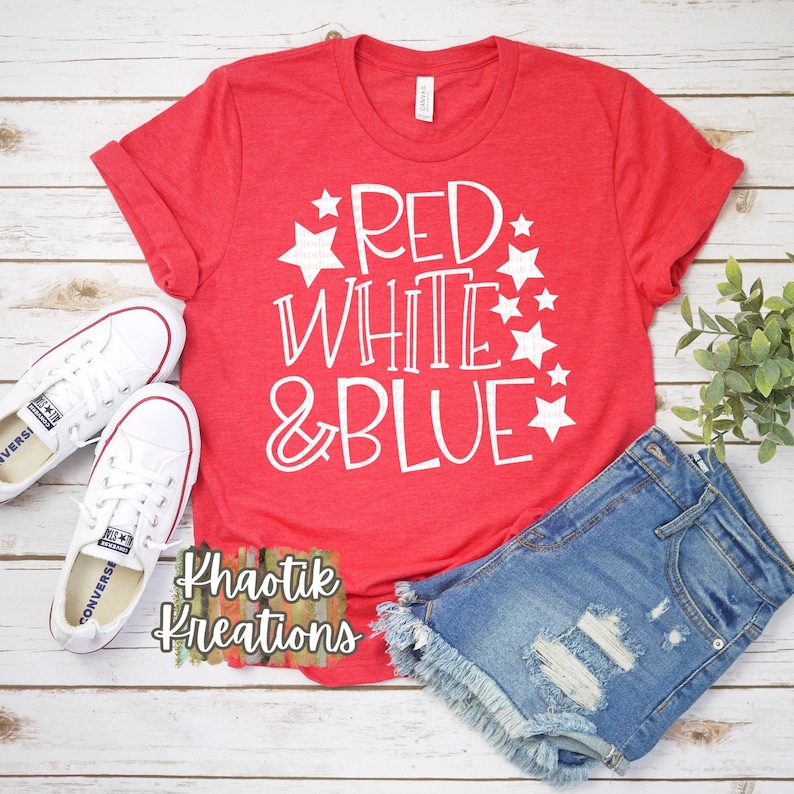 May include: Red, white, and blue graphic on a red t-shirt with white stars. The shirt is paired with denim shorts and white sneakers.