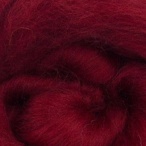 May include: A close-up of a deep red wool roving. The fibres are soft and fluffy, perfect for spinning or felting.