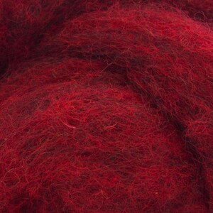 May include: Close-up of a deep red wool roving. The fibres are soft and fluffy, perfect for felting or spinning.