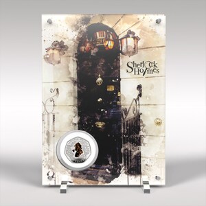 Op de afbeelding: Een heldere acryl display met een aquarel schilderij van een donkere deur, een lantaarn en de tekst "Sherlock Holmes". Een zilveren munt met een Sherlock Holmes illustratie is op de display gemonteerd. De display wordt ondersteund door een zilveren standaard.