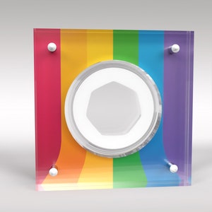 May include: A rainbow-colored glass plaque with a clear circular frame in the center. The frame has a white octagon shape inside. The plaque has silver metal accents on the corners.
