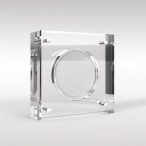 May include: A clear acrylic coin display case with a circular cutout in the centre. The case has four small metal posts on the sides.