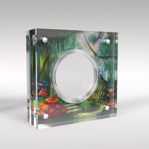 May include: A clear acrylic coin display case with a colorful image of a whimsical forest scene with mushrooms, flowers, and a path. The case has a circular opening in the center to display a coin.