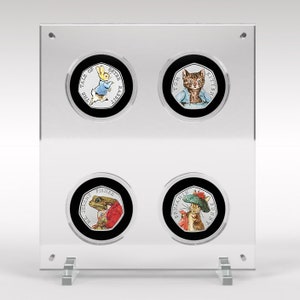 Puede incluir: Una vitrina de acrílico transparente con cuatro monedas de plata que representan personajes de los libros infantiles de Beatrix Potter. Las monedas muestran a Peter Rabbit, Tom Kitten, Mr. Jeremy Fisher y Mrs. Tiggy-Winkle.