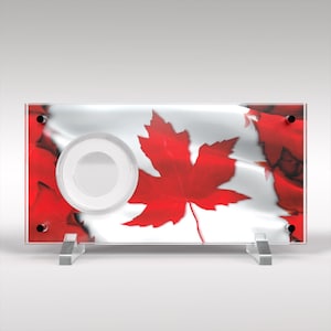May include: A clear acrylic coin display case with a red maple leaf design on a white background. The case has a circular opening in the center for displaying a coin.