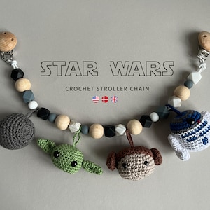 May include: A crocheted Star Wars stroller chain with characters from the movie, including Yoda, Princess Leia, and R2-D2. The chain is made with wooden beads, silicone beads, and clips.