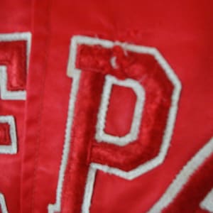 May include: Red satin jacket with white embroidered lettering that reads "EPA".