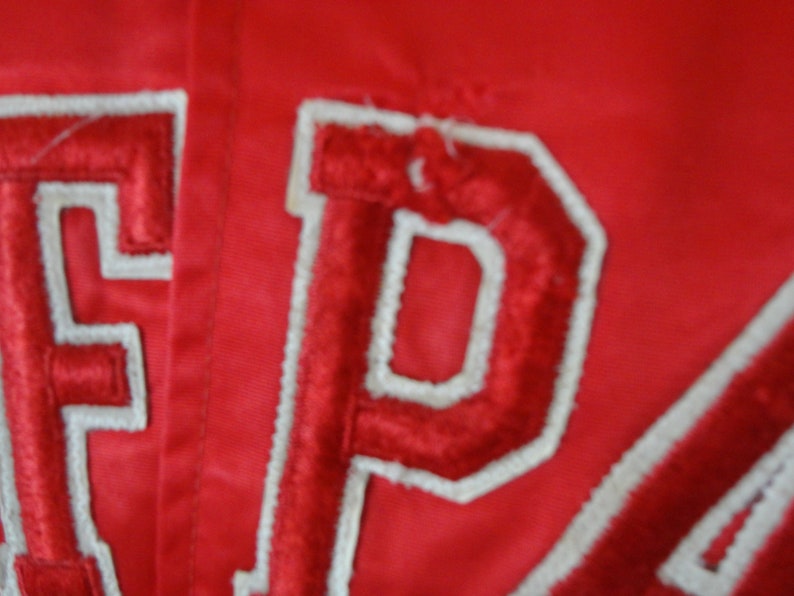 May include: Red satin jacket with white embroidered lettering that reads "EPA".