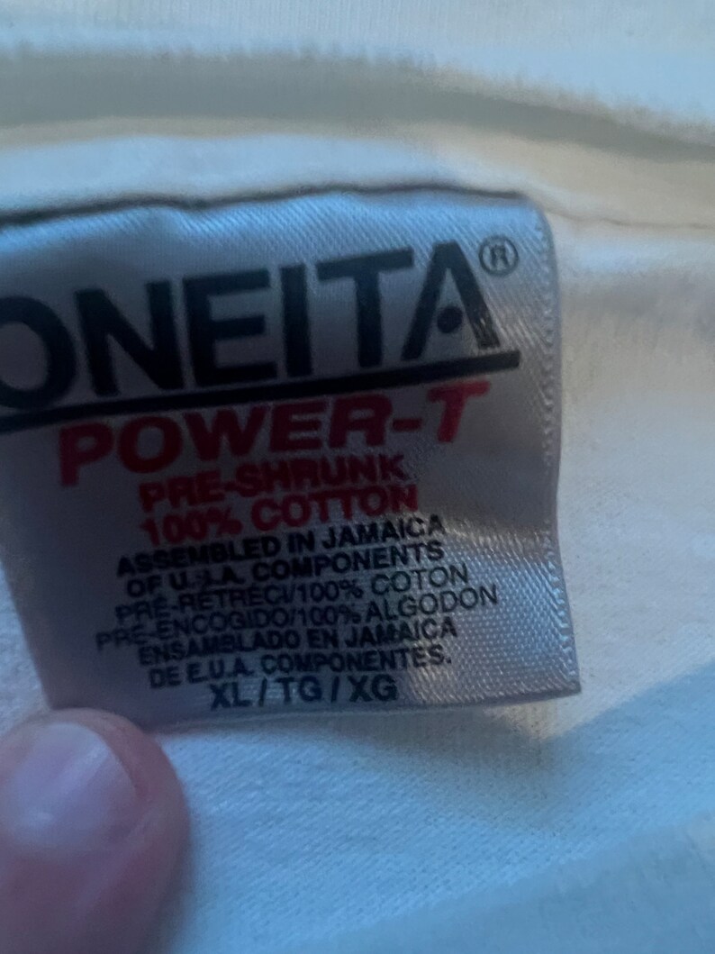 May include: White tag with black text that reads "ONEITA POWER-T PRE-SHRUNK 100% COTTON ASSEMBLED IN JAMAICA OF U.S.A. COMPONENTS PRE-RETRECI/100% COTON PRE-ENCOGIDO/100% ALGODON ENSAMBLADO EN JAMAICA DE E.U.A. COMPONENTES. XL/TG/XG"