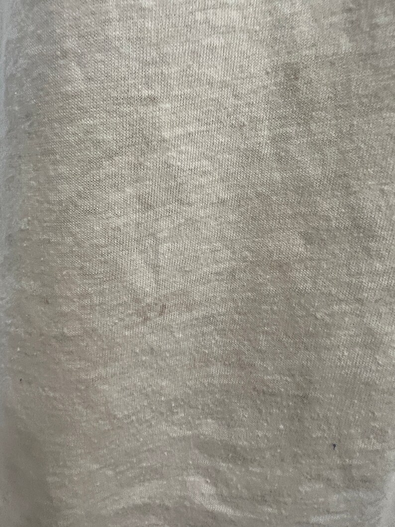 K&ouml;nnte beinhalten: Nahaufnahme eines hellgrauen Stoffes mit einer strukturierten Webart.