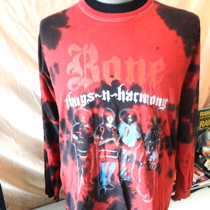 May include: Red and black long-sleeve shirt with the text "Bone thugs-n-harmony" in white gothic lettering. The shirt features a graphic of four figures in front of a red and black tie-dye pattern.