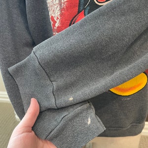 May include: A gray sweatshirt with a vintage Mickey Mouse graphic. The graphic features Mickey Mouse in a red and yellow outfit with the text "You've Got It, I'm In Deep, Oh..." in a speech bubble.