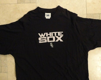 May include: Black t-shirt with a white "White Sox" logo and a small white and gray logo of a baseball team.