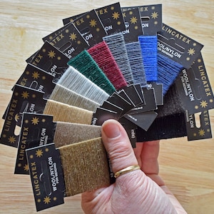 May include: A fan of 10 spools of wool/nylon thread for mending, in various colours, including black, blue, grey, red, green, beige, and brown. Each spool is labelled "Lincatex Wool/Nylon for Mending".
