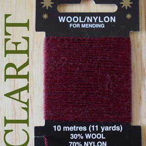 May include: A spool of claret red wool and nylon mending thread. The label reads "LINCATEX", "WOOL/NYLON FOR MENDING", "10 metres (11 yards)", "30% WOOL 70% NYLON", "No. LIN 101", "Made in England www.lincatex.co.uk".