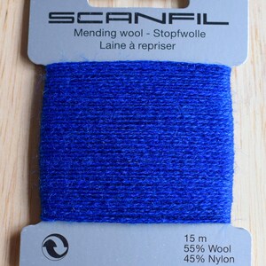 May include: A card of bright blue mending wool by Scanfil. The grey cardboard packaging features the brand name, the text Mending wool - Stopfwolle - Laine &agrave; repriser, and specifies 15 m of thread composed of 55% Wool and 45% Nylon.