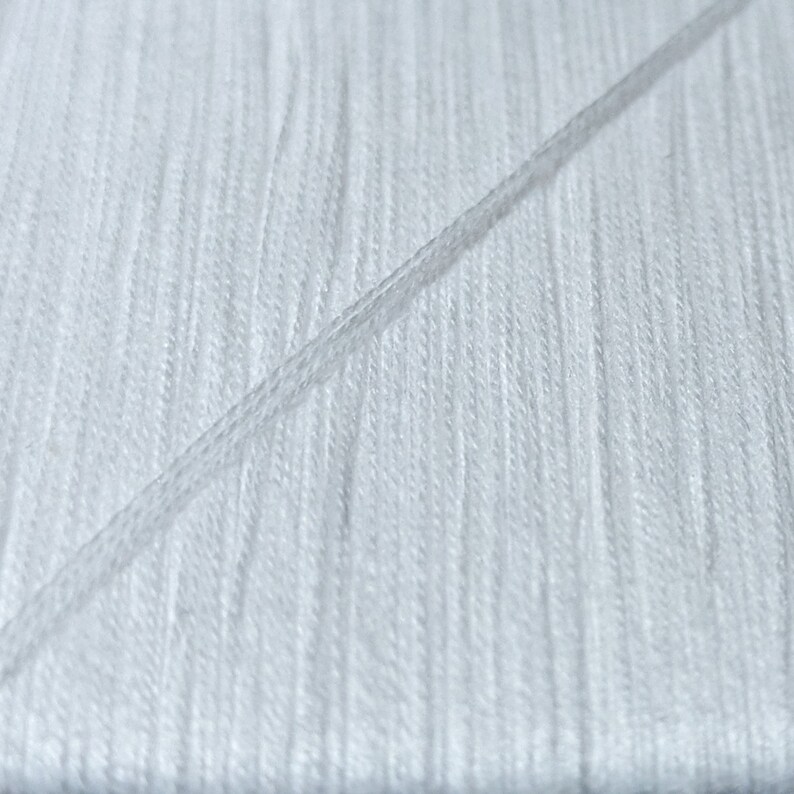 May include: Close-up of white thread, showing the texture and individual strands.