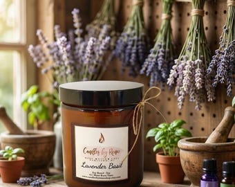 May include: A brown glass candle jar with a black lid and a white label reading Candles by Renee Lavender Basil. The label includes text about soy base and burn time. A thin twine string is tied around the neck of the jar.